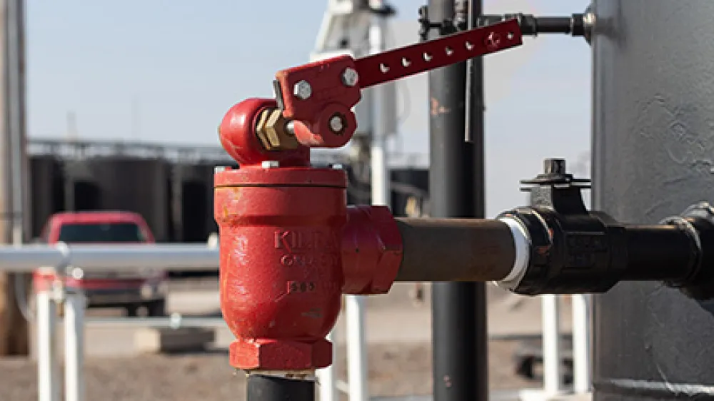 Lever operated dump valve at a well site