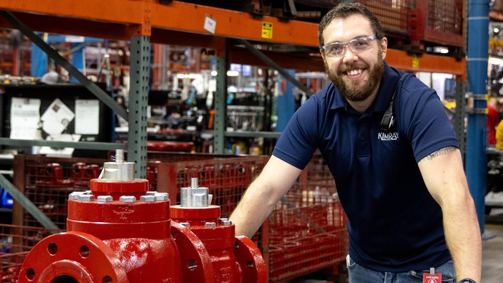 Kimray Team Member Smiling While Transporting a Valve